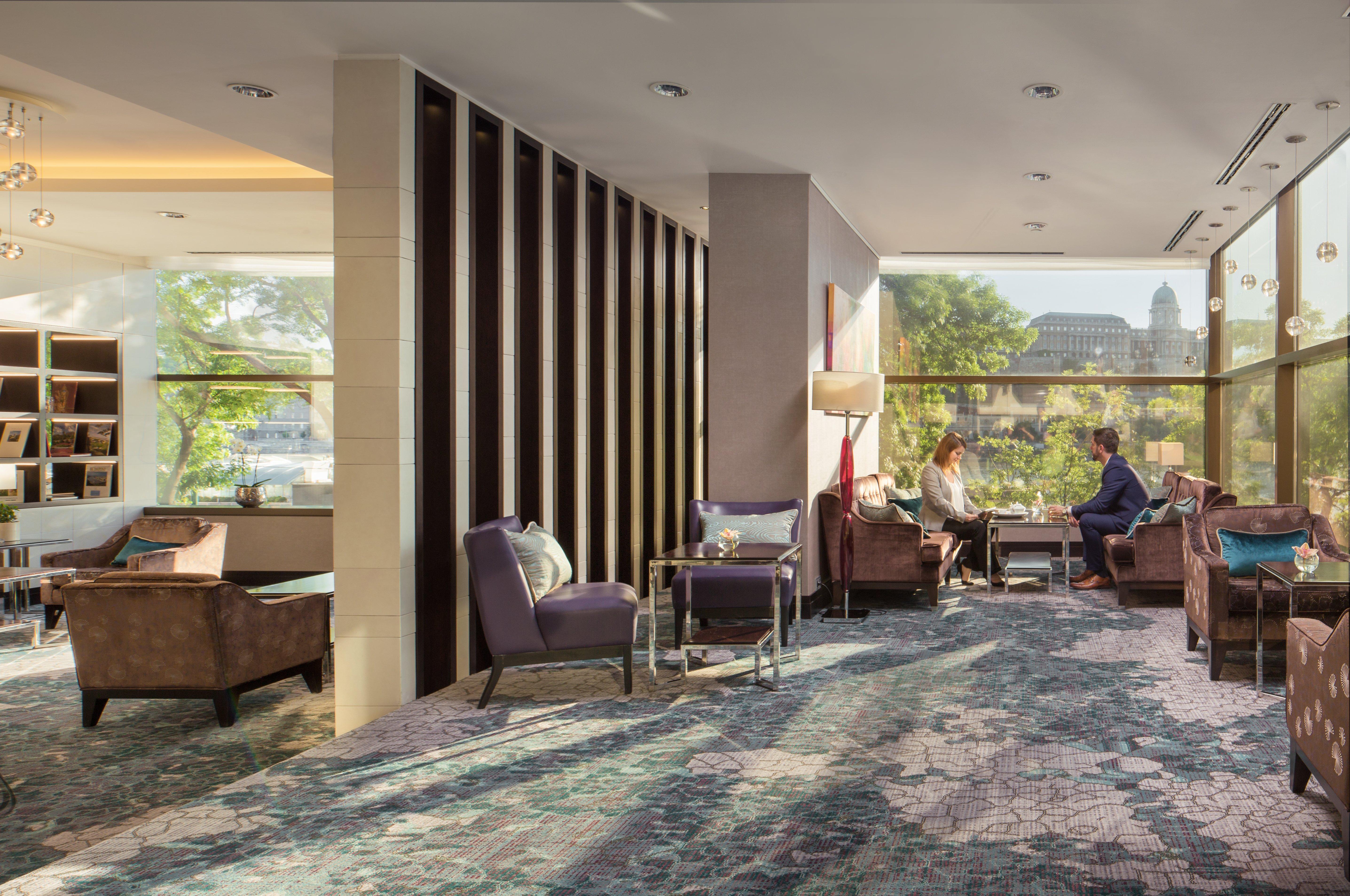 Intercontinental Budapest By Ihg Esterno foto The photo depicts a stylish lounge area, likely in a hotel or upscale establishment. It features modern furnishings, including plush chairs and a coffee table, arranged in a cozy manner that encourages conversation. Large windows allow natural light 
